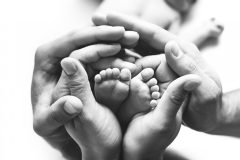 Babyfüsse in Händen schwarz weiß