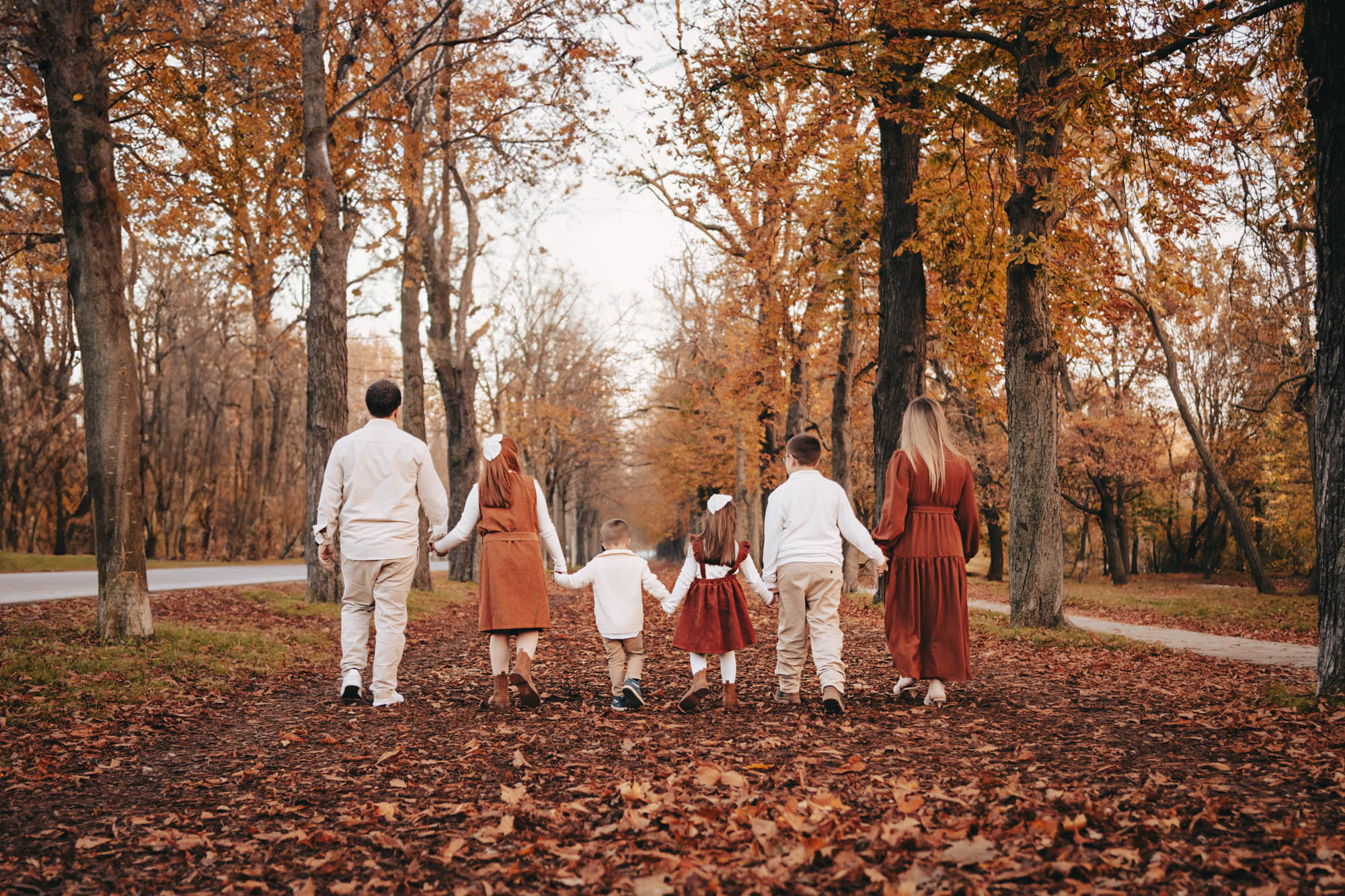 Familie spaziert bei einem herbstlichen Outdoor-Shooting in Wien durch den Wald.