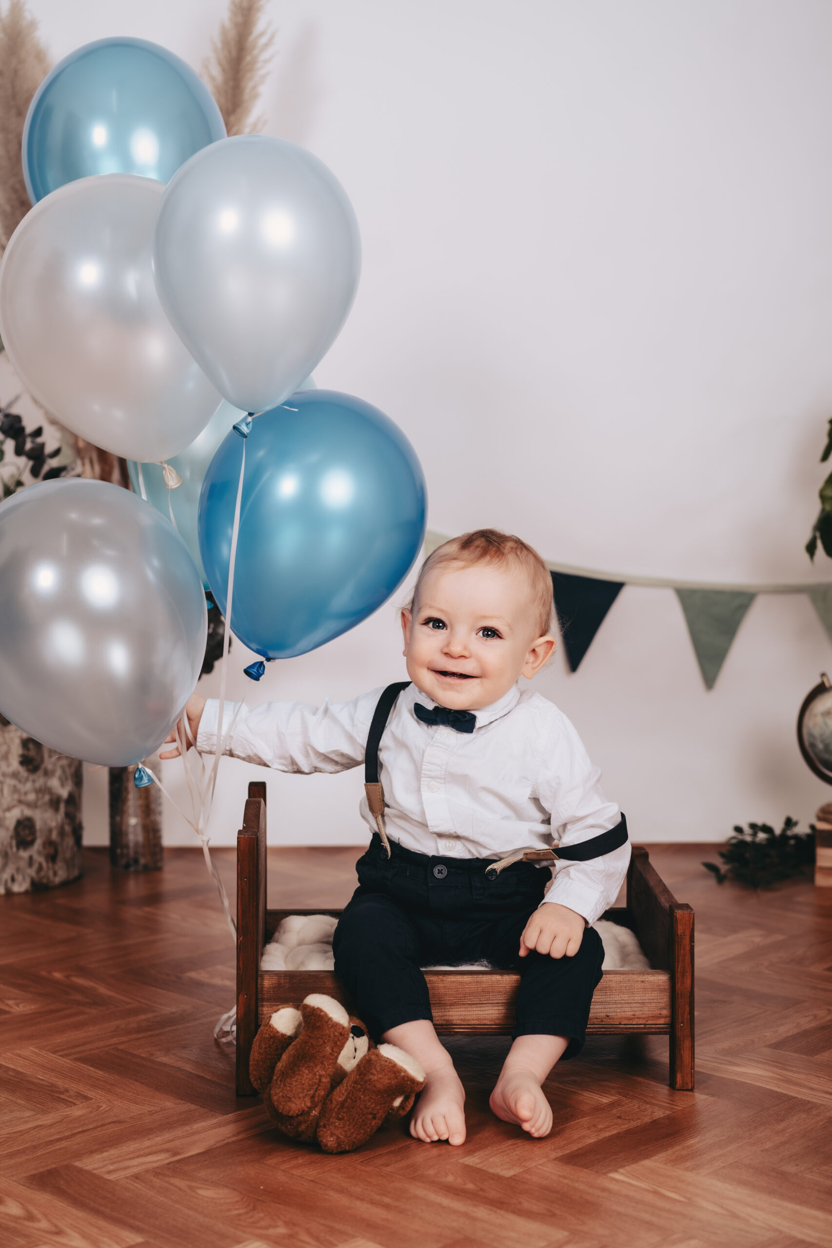 Einj&auml;hriges Kind sitzt l&auml;chelnd im Fotostudio.